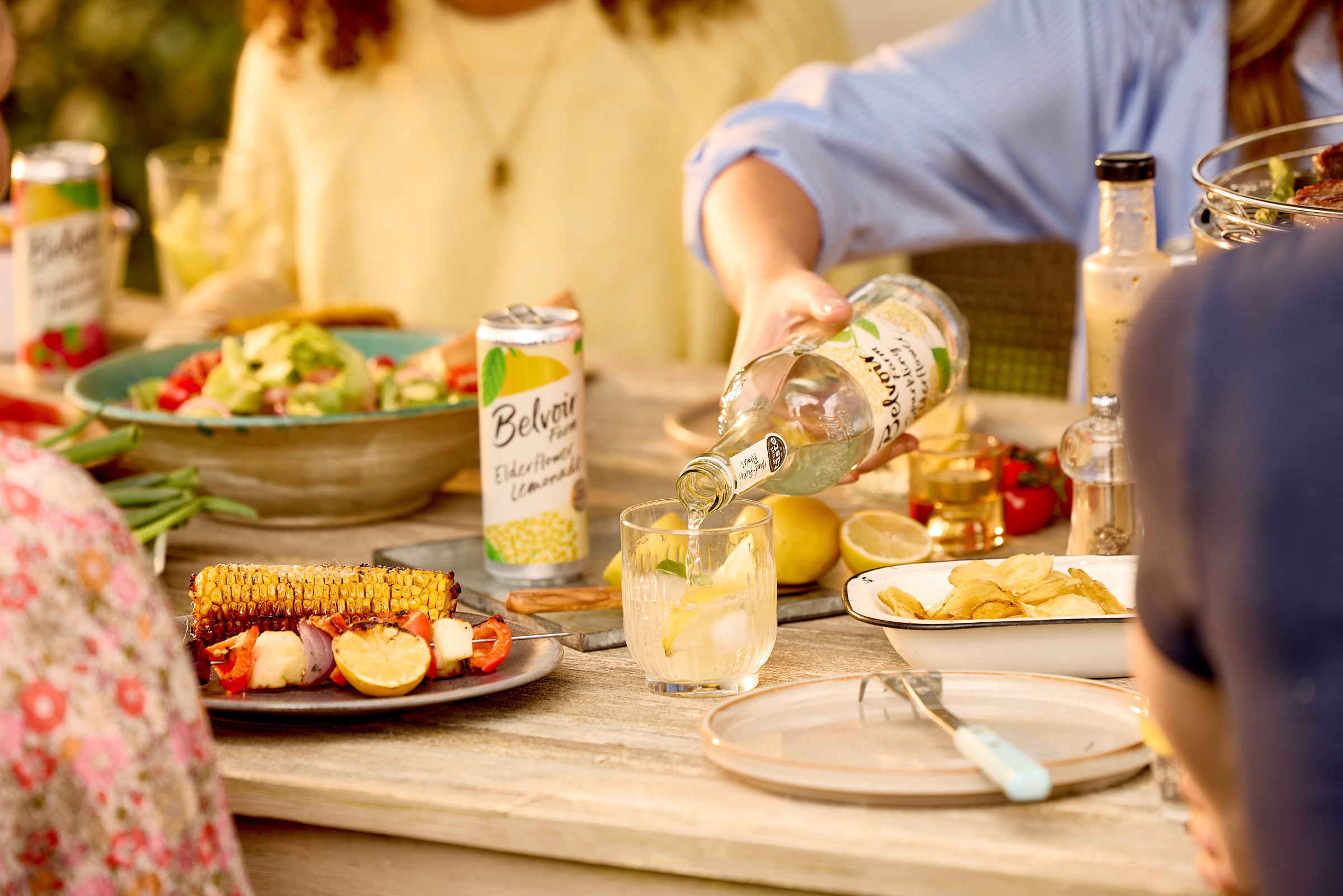 BBQ Table with Sparkling Elderflower being poured into a glass surrounded by delicious food