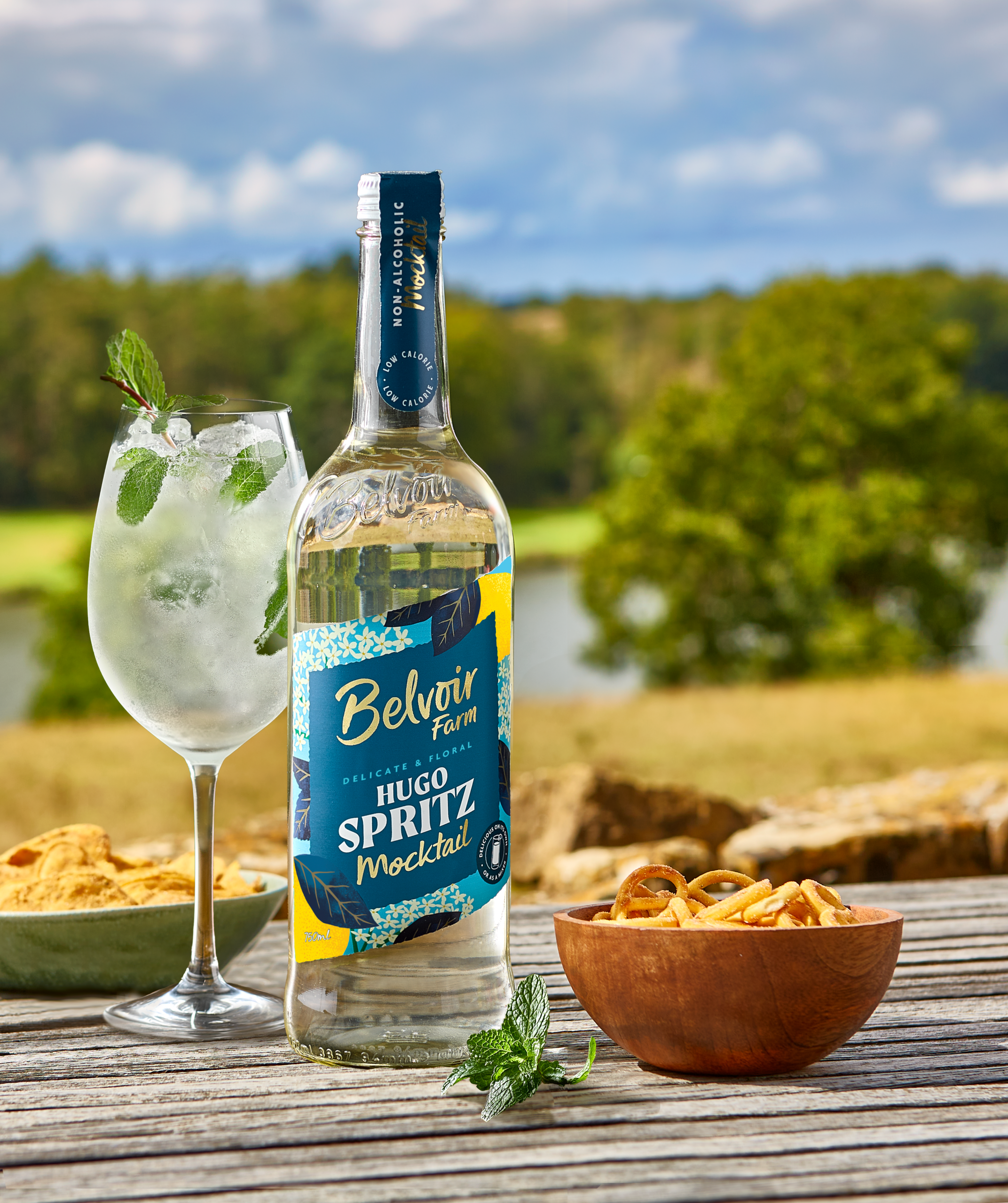 belvoir farm's hugo sprtiz mocktail on a table outside in the sunny countryside